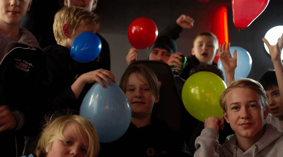 A group of children holding balloons and celebrating